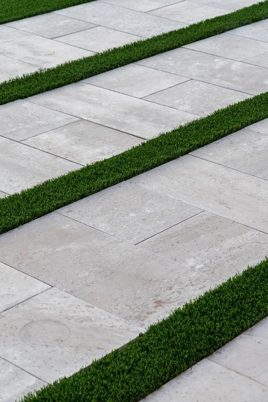 Detail shot of travertine pavers with artificial turf strips